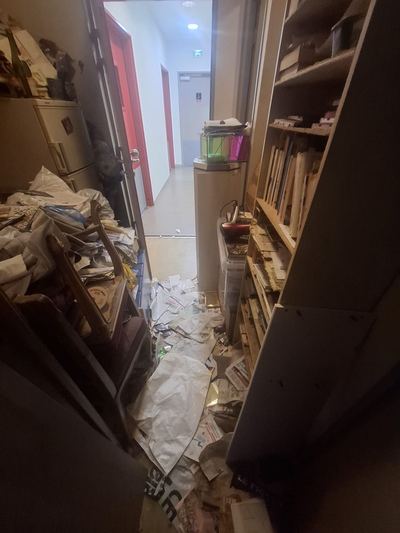 Couloir réduit à un passage étroit entre des piles de livres