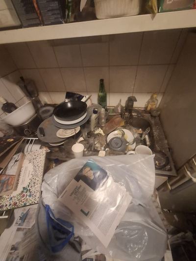 Plan de travail de cuisine entièrement recouvert de vaisselle et d'emballages