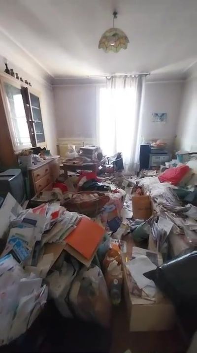 Salon haussmannien envahi par les papiers, les sacs et les cartons