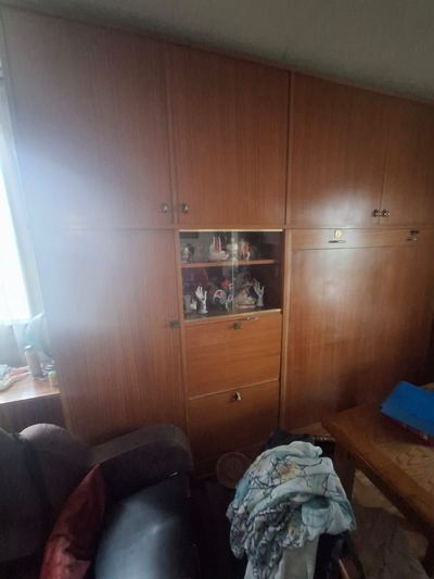 Armoire de chambre pleine, affaires entassées devant