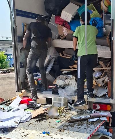 Deux opérateurs de notre équipe chargeant le camion en fin de débarras, avant départ en déchetterie