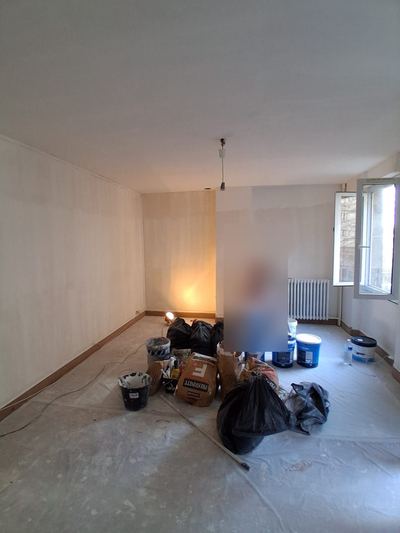 Séjour en cours de remise en état, sol bâché et murs préparés