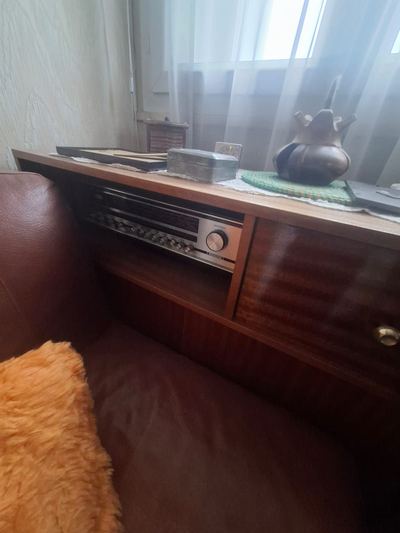 Chambre encore meublée avant débarras : buffet en bois, poste de radio et literie
