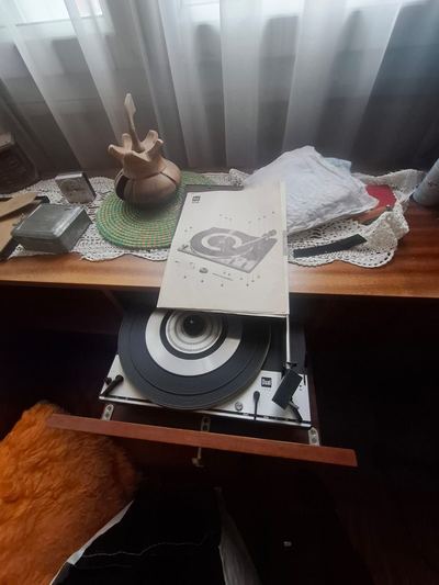 Tourne-disque et linge de maison poses sur un meublé avant enlèvement